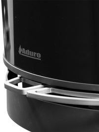 Side view of Aduro 22.3 Lux wood burning stove with glossy glass door and elegant pedestal design.