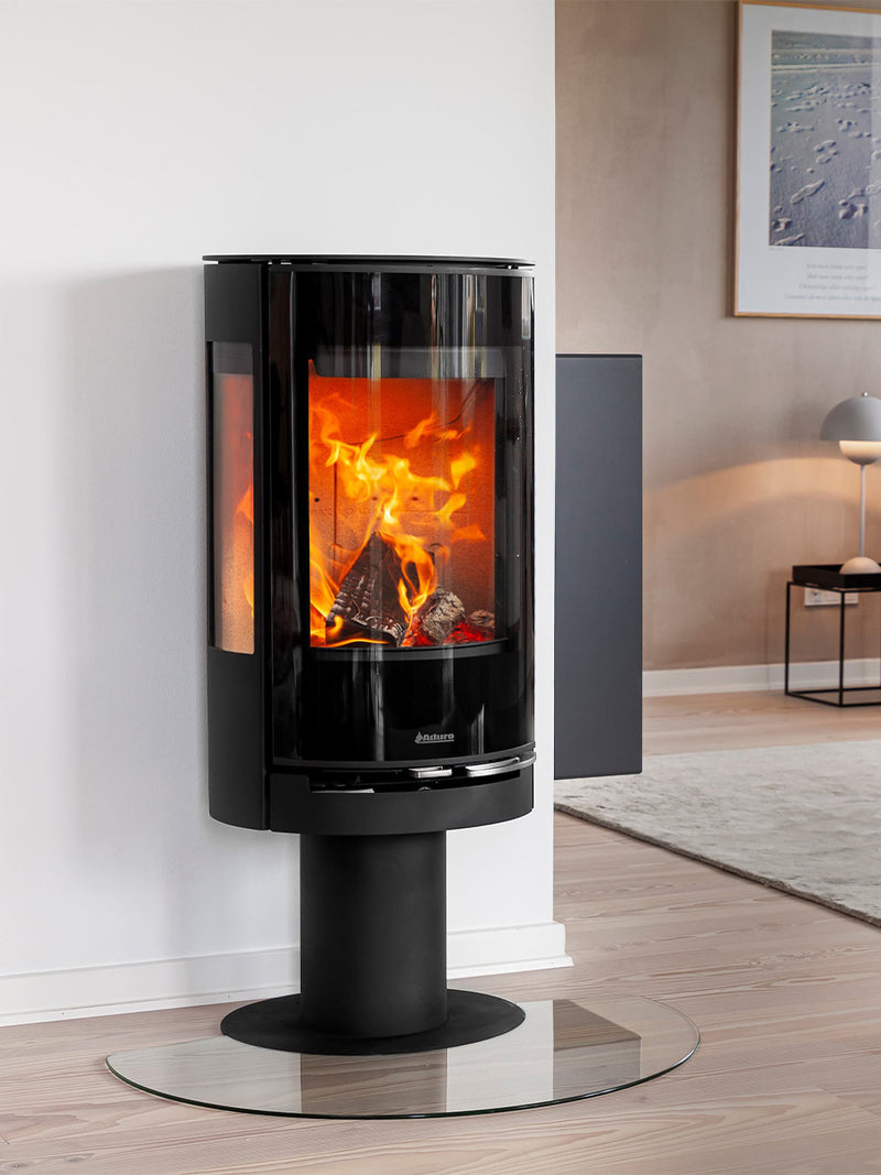 Slender Aduro 22.3 Lux wood burning stove with glossy glass door and pedestal design, showcasing flames from the front view.