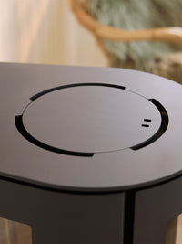 Side view of the Aduro 23 wood burning stove with curved glass and elegant legs, showcasing its modern design.