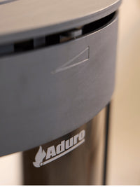 Side view of the Aduro 23 wood burning stove with curved glass and elegant legs, showcasing its modern design.