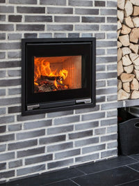 Side view of Aduro 5.1 wood burning stove inset, showcasing minimalist design and large glass door for fire view.