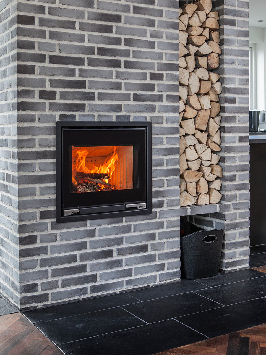 Minimalist Aduro 5.1 wood burning stove inset with large glass door and sleek flat surface design, showcasing modern elegance.