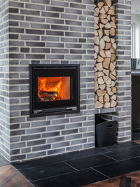 Minimalist Aduro 5.1 wood burning stove inset with large glass door and sleek flat surface design, showcasing modern elegance.