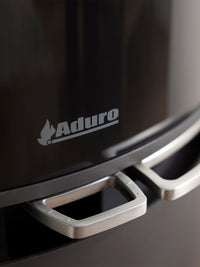 Side view of Aduro 9.8 Lux wood burning stove with black glass door and integrated handles, showcasing its elegant design.