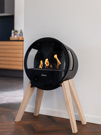 Side view of Aduro B1 bioethanol fireplace with glass sides, showcasing elegant design and flames inside.