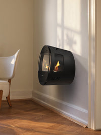 Side view of Aduro B1 bioethanol fireplace with glass sides and oak legs, showcasing its elegant design and fire view.