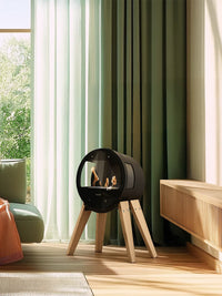Side view of Aduro B1 bioethanol fireplace with glass sides and elegant design, showcasing the flames and installation options.