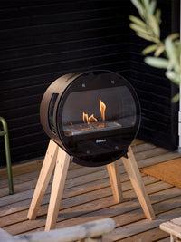 Side view of Aduro B1 bioethanol fireplace with elegant glass door and sides, showcasing the flame and Danish design.