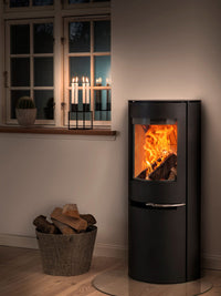 Curved glass front of Aduro H2 Hybrid Stove in sleek black, showcasing a cozy fire, ideal for corner installation.
