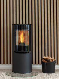Side view of Aduro H4 Lux Hybrid Stove with glossy glass door and curved front, showcasing sleek design and finish.