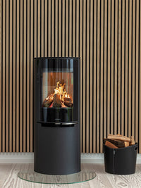 Elegant Aduro H4 Lux Hybrid Stove with glossy glass door and curved front, suitable for wall or corner installation.