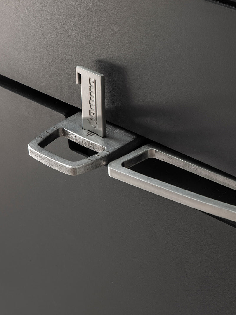 Side view of Aduro H5 Hybrid Stove showcasing its cubic design, smooth surfaces, and elegant handles in a modern setting.