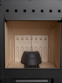 Side view of the Aduro H5 Hybrid Stove showcasing its cubic design, smooth surfaces, and elegant handles.
