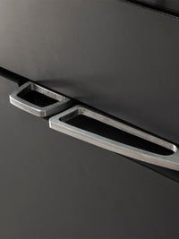 Side view of Aduro H5 Hybrid Stove showcasing its cubic design, smooth surfaces, and elegant handles in a modern interior.
