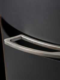Side view of Aduro P5 wood pellet stove with curved glass and elegant side panels, showcasing 180-degree flame view.