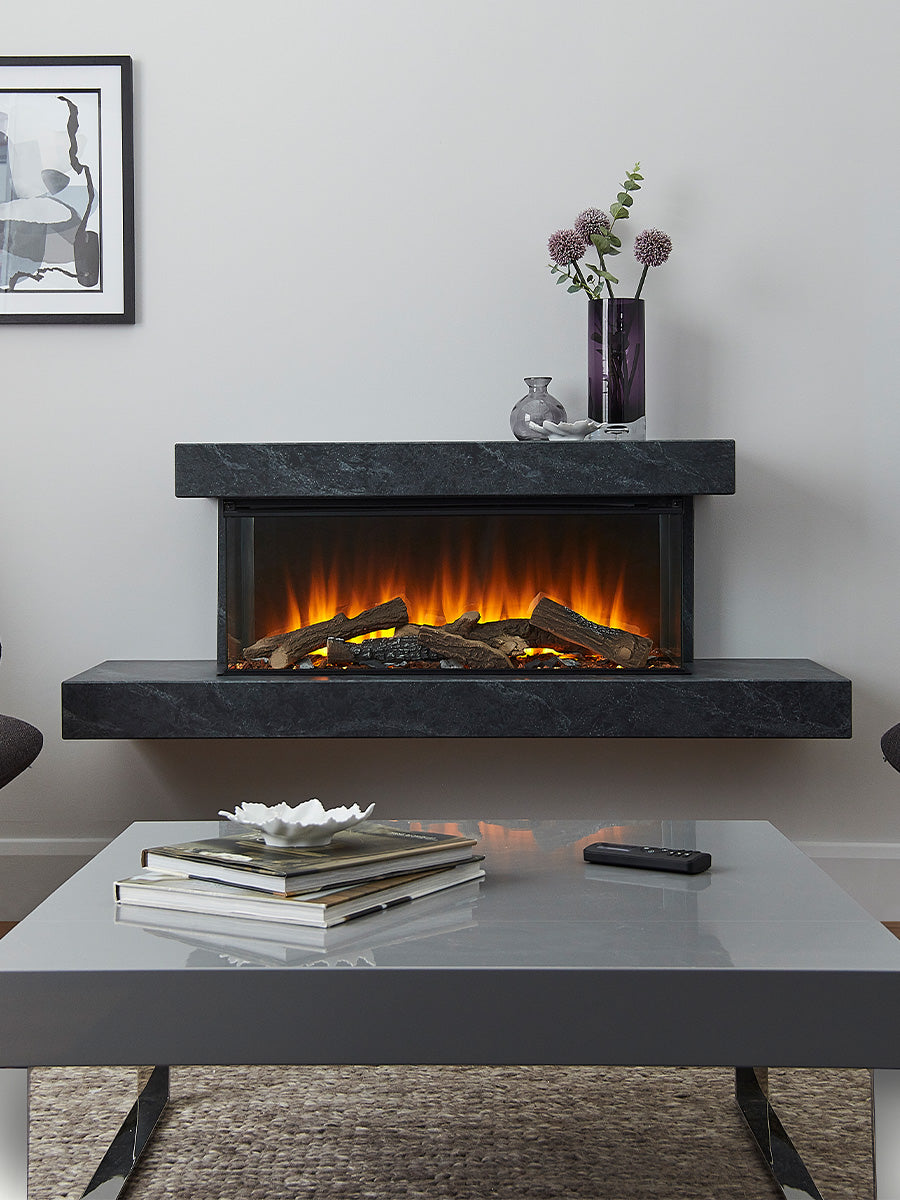 Side view of the British Fires Brockenhurst electric fire suite, showcasing its sleek design and three-sided glass viewing.