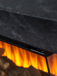 Side view of the British Fires Brockenhurst electric fire suite, showcasing its sleek design and three-sided glass viewing.