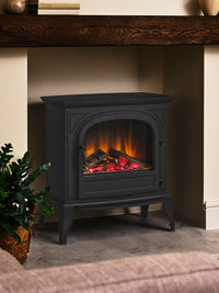 Side view of British Fires Hinton Electric Stove with cast iron body and hand-scorched oak logs, showcasing intricate details.