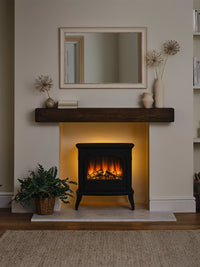 Side view of British Fires Hinton Electric Stove showcasing cast iron body and hand-scorched oak logs with LED mood lighting.