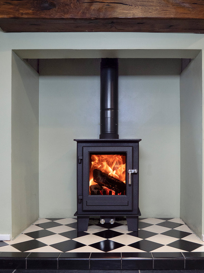 Compact wood burner in black with a sleek design, perfect for small spaces like cottages and narrowboats.