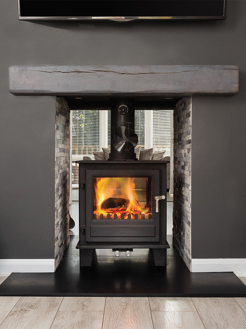 Double-sided wood burner in sleek black with glass panels, showcasing modern design and multi-fuel capability.