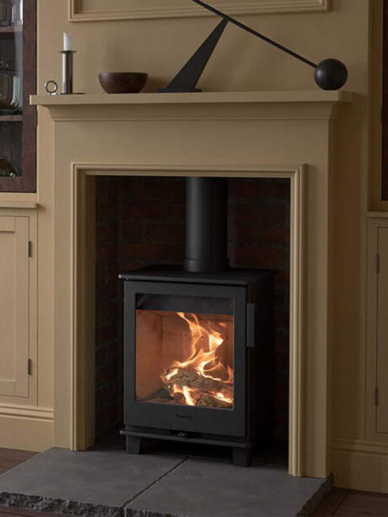 Compact Contura 110 wood burning stove in black cast iron, showcasing its sleek design and simple controls.