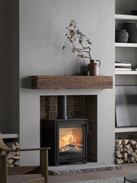 Side view of the Contura 210 wood burning stove with a classic cast iron door and sleek design, showcasing its compact size.