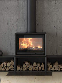 Side view of Contura 330G wood burning stove with glass door, showcasing sleek design and log compartment.