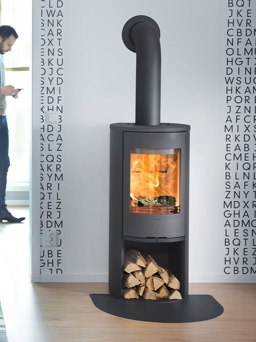Contura 510 wood burning stove with cast iron door, large side lights, and curved design in a cozy living room setting.
