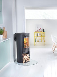 Side view of the Contura 510G wood burning stove with a large glass door, showcasing its sleek design and curved shape.