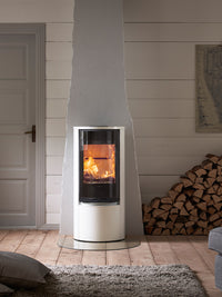 Side view of the Contura 510G wood burning stove with a sleek glass door and curved design, showcasing its modern style.