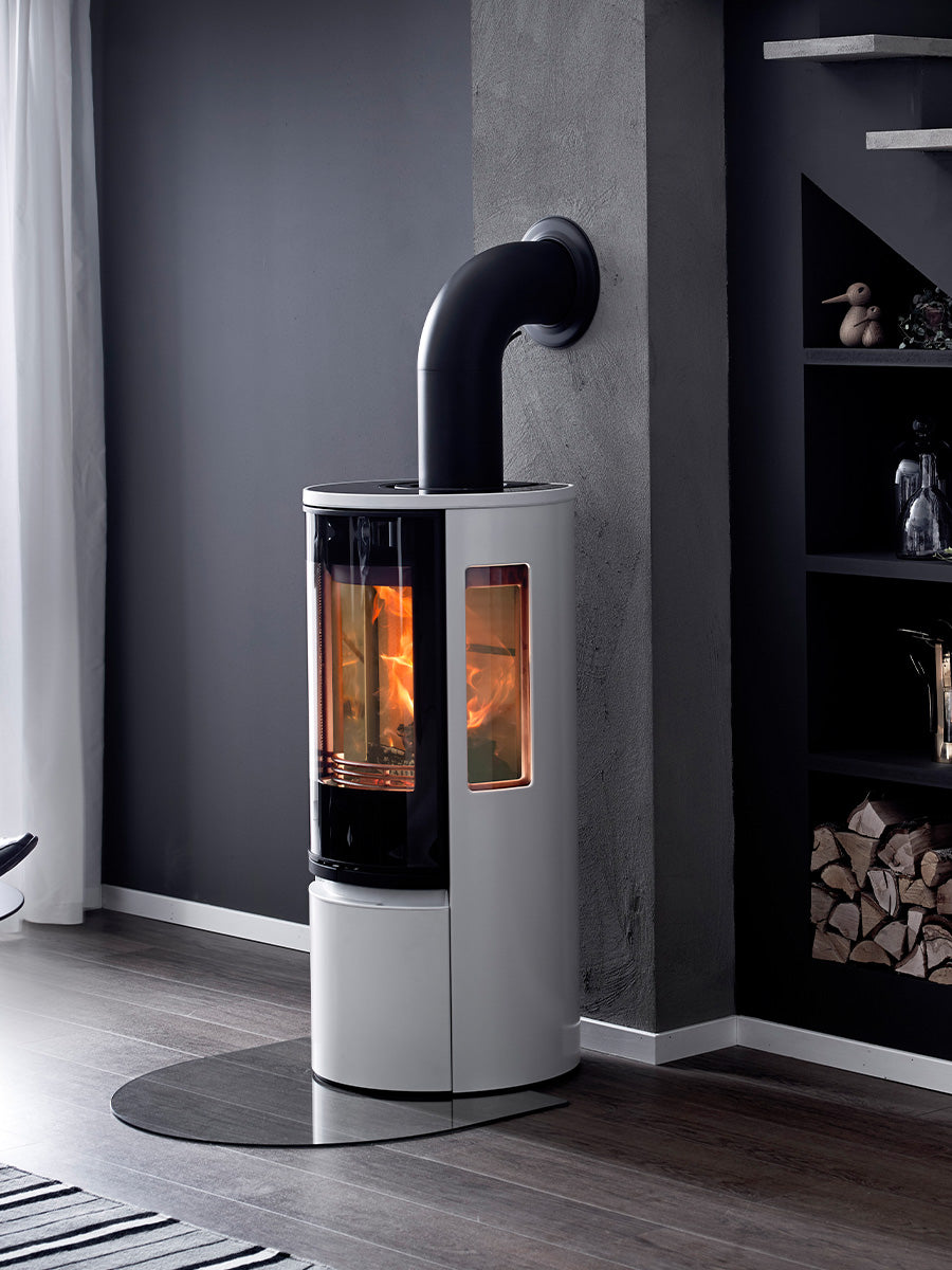 Modern black wood burning stove with large glass door, showcasing sleek design and clean lines.