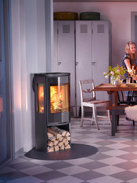 Side view of the Contura 556G wood burning stove with a glass door, showcasing its sleek design and modern legs.