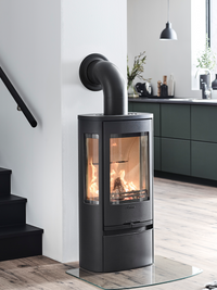 Side view of the Contura 856 wood burning stove showcasing its cast iron door and large side panes for visibility.