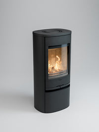 Side view of the Contura 910 wood burning stove with a cast iron door and soapstone top, showcasing its compact design.