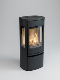 Side view of the Contura 956 wood burning stove showcasing its cast iron door and large glass panels.