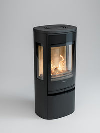 Side view of Contura 956G wood burning stove with glass door and side panels, showcasing flames and sleek design.