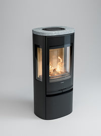 Side view of Contura 956G wood burning stove with glass door and side panels, showcasing flames and log compartment.
