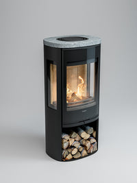 Side view of Contura 956G wood burning stove with glass door and soapstone top, showcasing flames and sleek design.