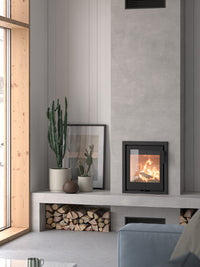 Side view of Contura i1 wood burning fireplace insert with cast iron door and sleek design in a modern setting.