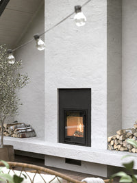 Side view of the Contura i2G wood burning fireplace insert with a sleek glass door and compact design in black finish.