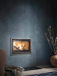 Contura i7 wood burning fireplace insert with cast iron door and steel frame, showcasing a sleek, modern design.