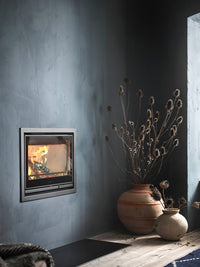 Side view of Contura i7 wood burning fireplace insert with cast iron door and steel frame, showcasing its sleek design.