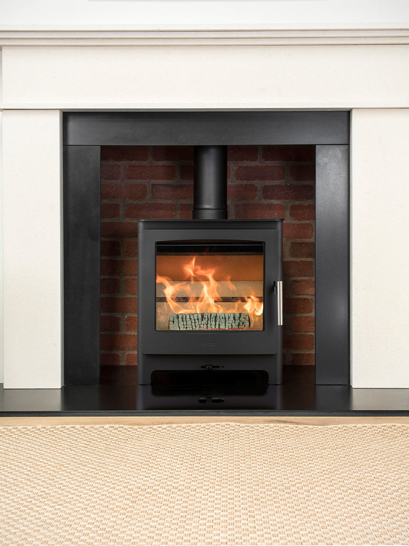 Side view of Heta Ambition 5 wood burning stove with cast iron door and large glass for flame visibility.