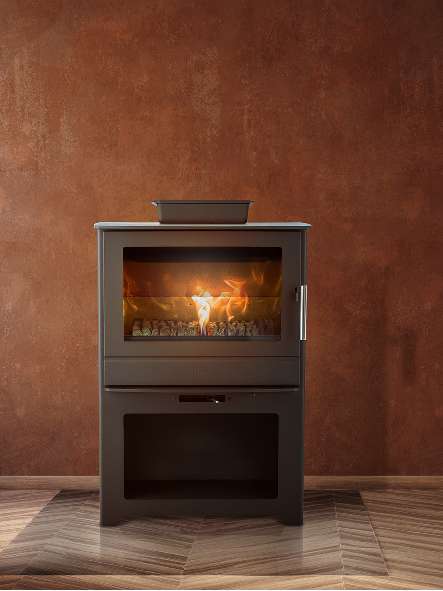 Large black steel wood burning stove with panoramic flame view and integrated log store, showcasing its sleek design.