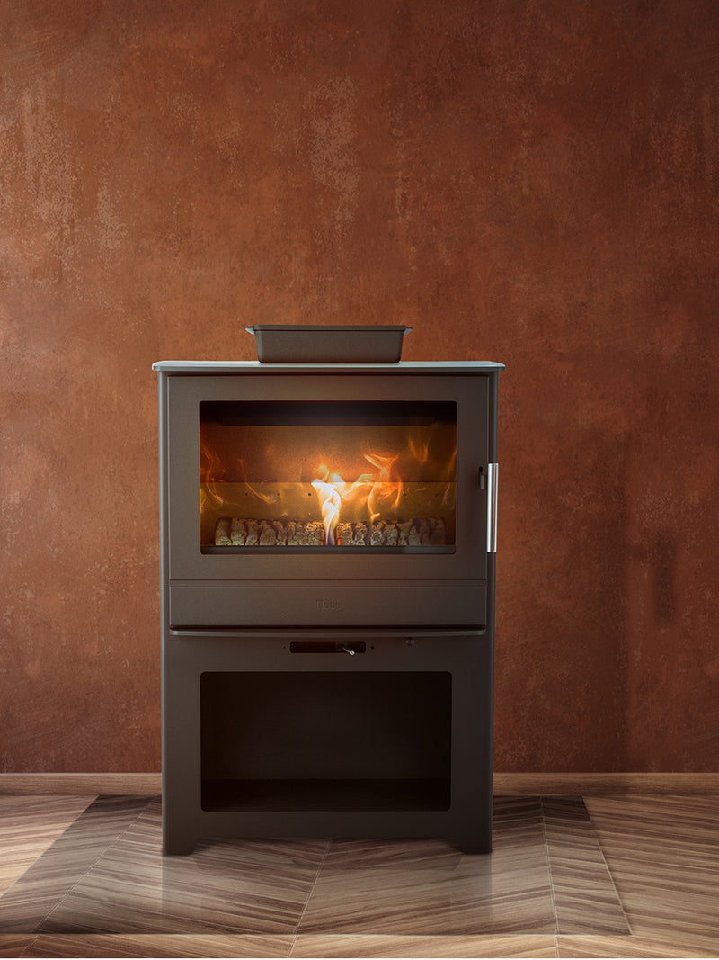 Large black steel wood burning stove with panoramic flame view and integrated log store, showcasing its sleek design.