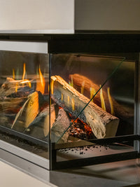 Side view of Kalfire E-One 130S three-sided electric fireplace showcasing holographic flames and sleek glass panels.