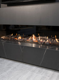 Side view of Kalfire G170/37S three-sided gas fire showcasing flames through large glass panels in a modern setting.