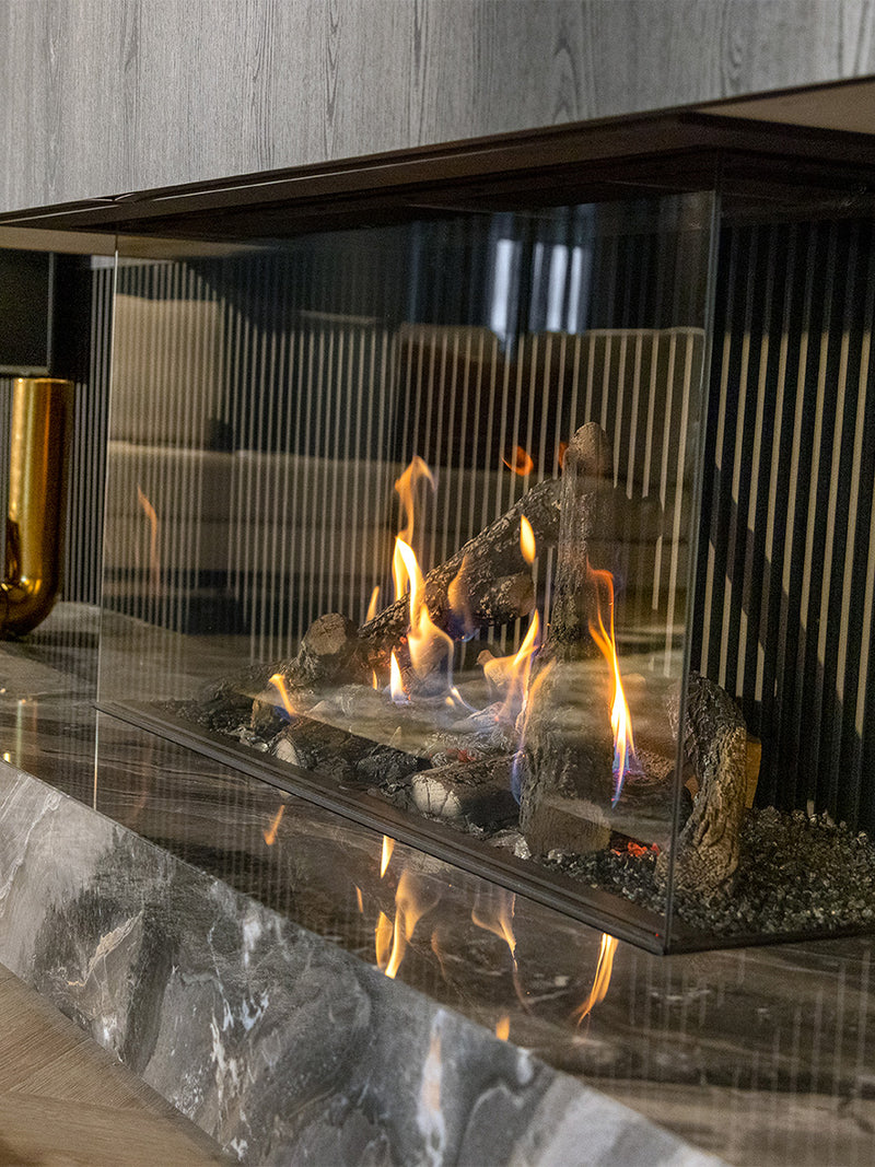 Side view of Kalfire Gi115/55S three-sided gas fireplace with dynamic flames and sleek black frame.