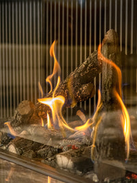 Side view of Kalfire Gi115/55S three-sided gas fireplace showcasing dynamic flames and sleek glass panels.